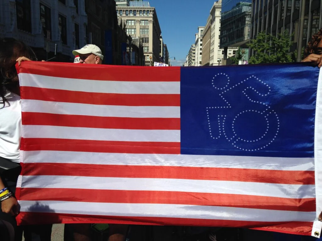 The United States of America Flag with the stars in the shape of a person in a wheel chair.